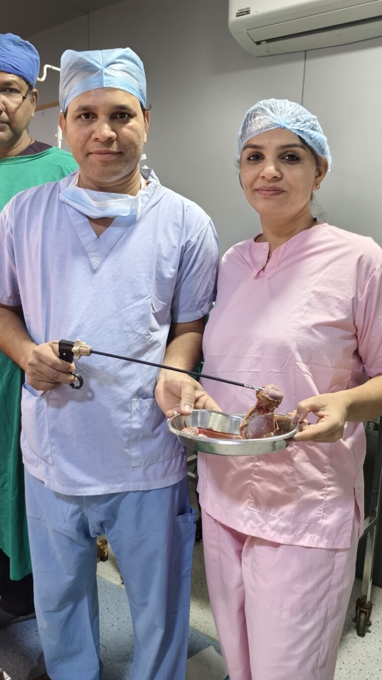 Dr. Archana Mohana with surgical team showcasing laparoscopic specimen – expert gynecologist in Indore