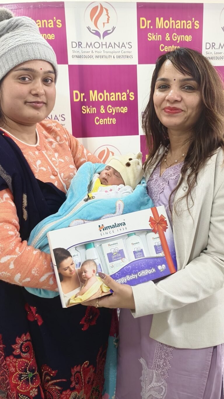 Dr. Archana Mohana with a new mother and newborn baby, presenting a Himalaya baby care gift pack at Dr. Mohana’s Skin & Gynae Centre.