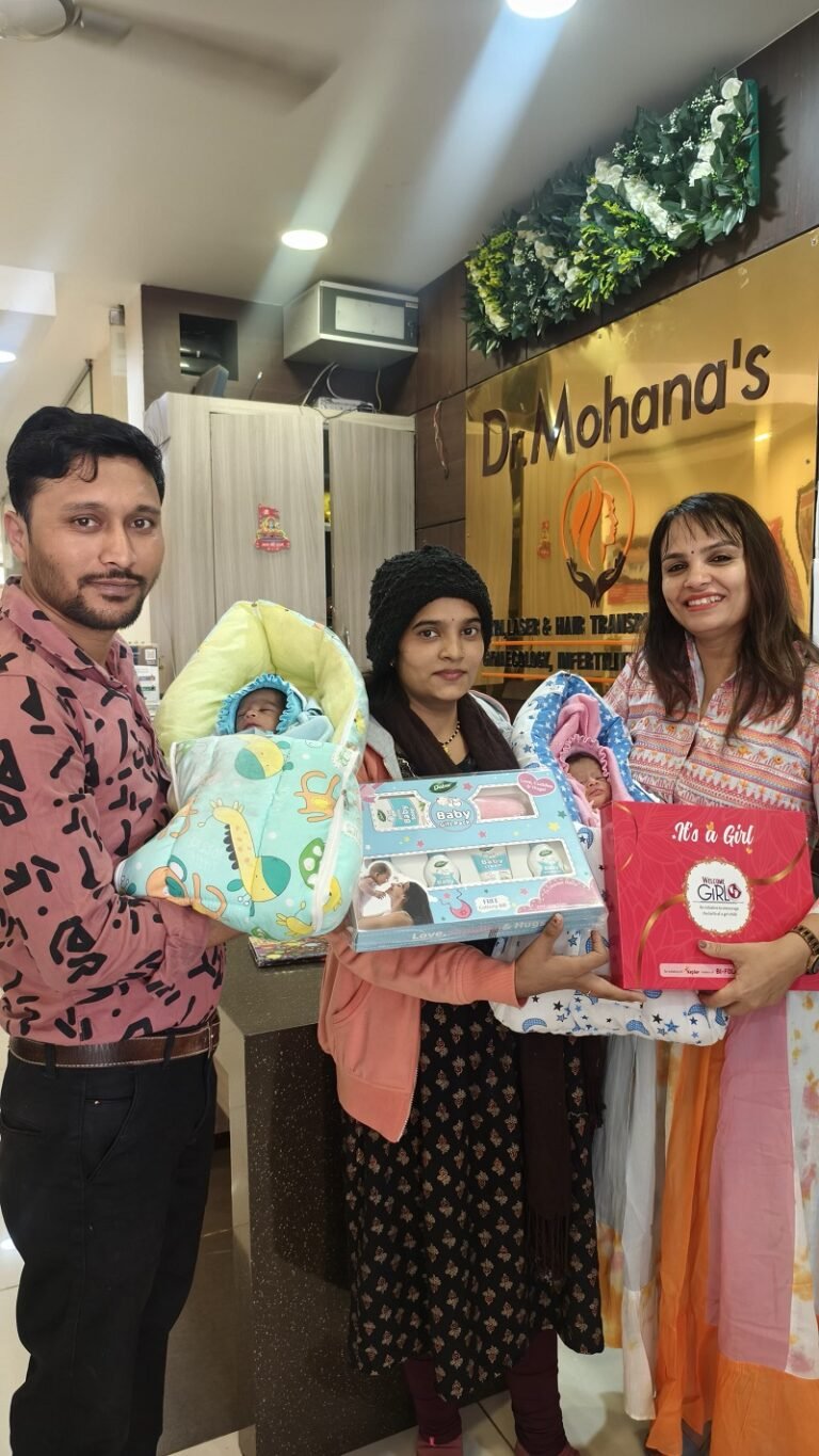 Dr. Archana Mohana with new parents holding twin babies, presenting baby care gift packs at Dr. Mohana’s Skin & Gynae Centre.