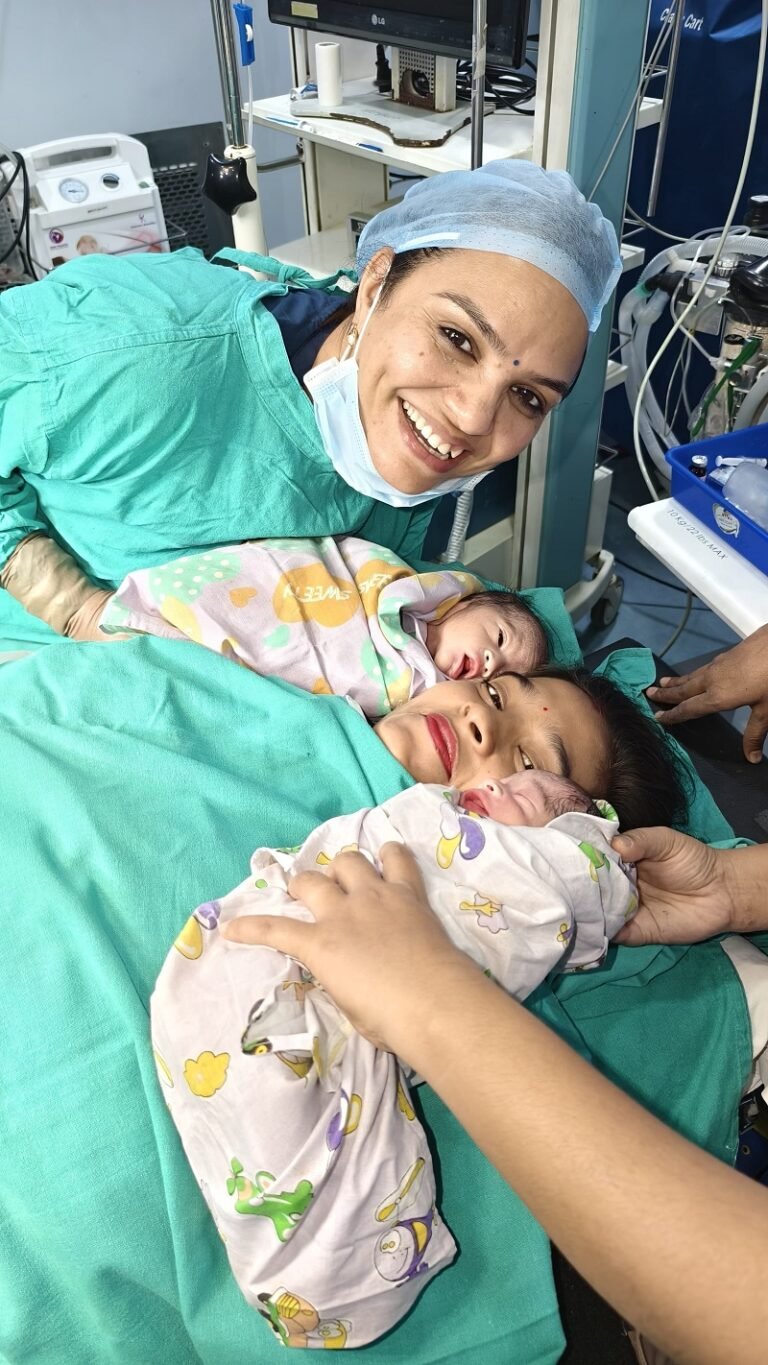 Dr. Archana Mohana holding a newborn wrapped in a brown blanket after a successful delivery in Indore