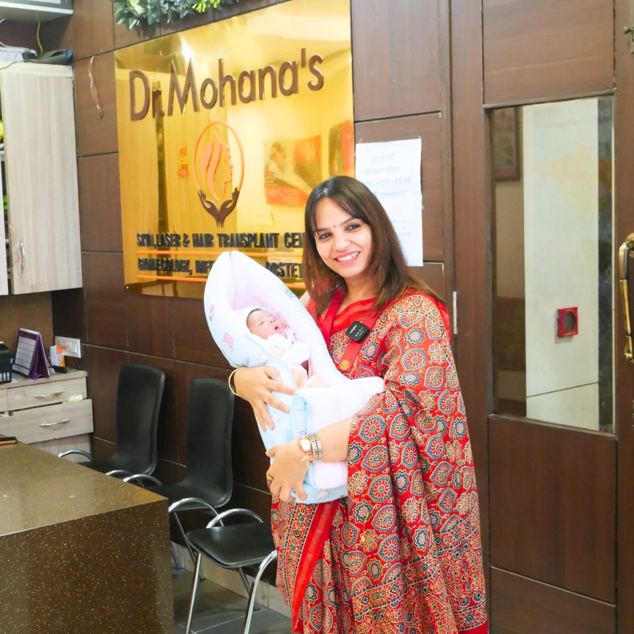 Dr. Archana Mohana holding a newborn baby at her gynecology and laser clinic in Indore