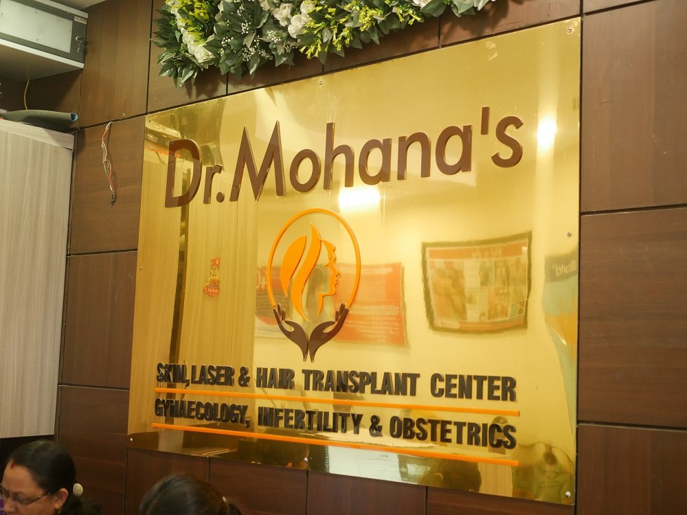 Clinic name board of Dr. Mohana’s Skin, Laser & Hair Transplant Center, highlighting services in gynecology, infertility, obstetrics, and advanced cosmetic care. 